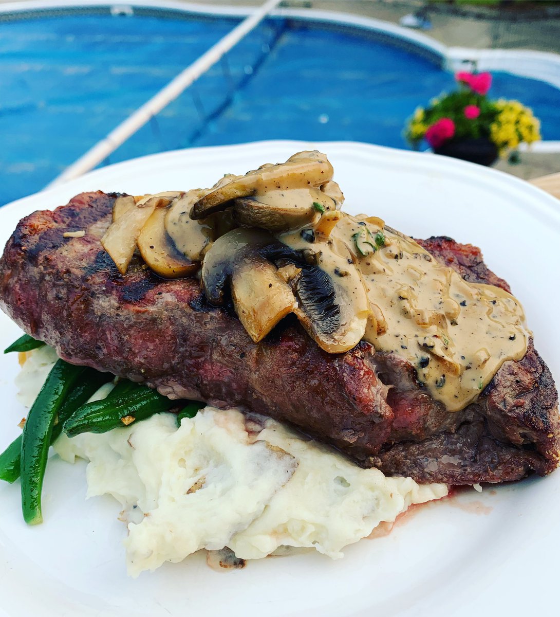 Med-rare striploin over green bean almandine and garlic mashed potatoes.  Topped w a peppercorn sauce #Foodie