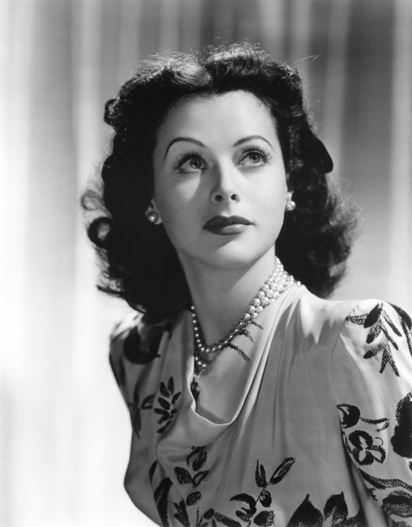 PhysInHistory's tweet photo. Hedy Lamarr, a famous Hollywood actress from the 1940s, was also a remarkable inventor. She co-invented a frequency-hopping system during World War II to prevent enemies from intercepting torpedoes. This invention laid the groundwork for today's Wi-Fi, GPS, and Bluetooth technologies.

Born in Vienna in 1914 as Hedwig Eva Maria Kiesler, she starred in a number of European films before fleeing from her husband, a wealthy Austrian ammunition manufacturer, and moving to Hollywood. There, she became known as Hedy Lamarr and quickly rose to fame as one of the era's most popular and glamorous actresses. But beyond her acting career, Lamarr had a keen interest in science and technology.

Her most notable contribution to technology came during World War II when she learned of the problems with radio-controlled torpedoes. At the time, Allied forces were using radio signals to control their torpedoes, but these signals were susceptible to jamming by enemy forces, which would send the torpedoes off course.

With the aim of creating a more secure system, Lamarr, together with composer George Antheil, came up with the idea of frequency hopping. In their proposed system, the control signal would rapidly switch, or "hop," across multiple frequencies, according to a synchronized pattern known to both the transmitter and receiver but not to the enemy. Even if one frequency were jammed, the system would simply hop to the next, allowing the torpedo to reach its target.

Though the U.S. Navy did not adopt Lamarr and Antheil's technology until the 1960s, the principles behind their frequency-hopping system are widely used today. Variations of frequency-hopping spread spectrum technology form the foundation of modern wireless communication technologies, including Wi-Fi, GPS, and Bluetooth.

Despite the importance of Lamarr's invention, her contribution was largely overlooked for decades. It was not until 1997, when she and Antheil were honored with the Electronic Frontier Foundation Pioneer Award, that her work began to receive broader recognition. Later that year, Lamarr also became the first woman to receive the Invention Convention's BULBIE Gnass Spirit of Achievement Award, often dubbed "the Oscars of inventing."

The story of Hedy Lamarr is a testament to the remarkable impact that curious and inventive minds can have, no matter what field they are traditionally associated with. It also underscores the importance of recognizing and celebrating the often underappreciated contributions of women to science and technology.