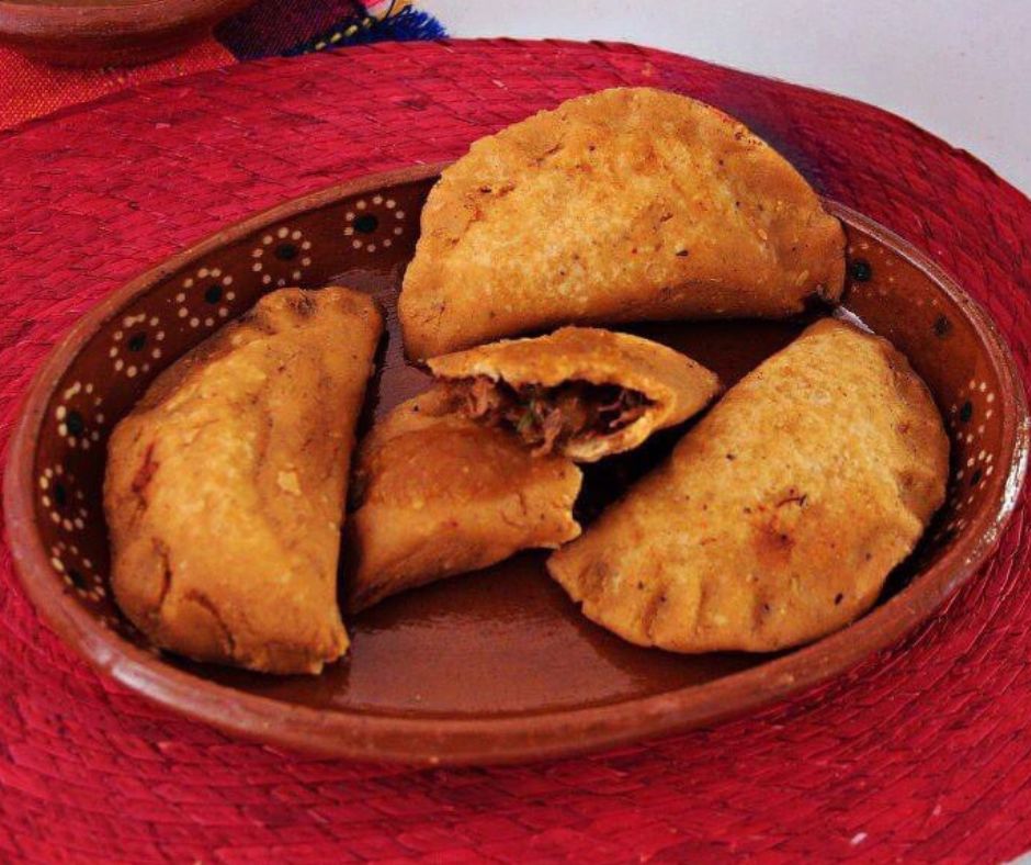 😋🍽️ Las "brujitas" son deliciosas empanadas de maíz fritas, rellenas de carne deshebrada, frijoles o papas con queso. Disfruta de este antojito típico en el #PuebloMágico de #Sombrerete, #Zacatecas. 🥙