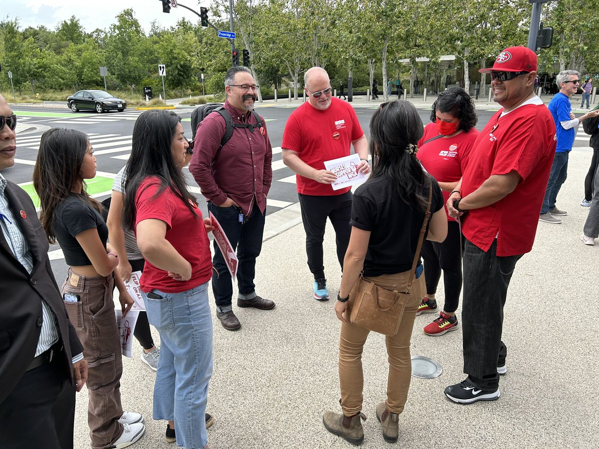 WGAW board member @LizAlps  talks with the media while @Teamsters, @LIUNA, @AlphabetWorkers, @sobaylabor and @CalNurses members assemble up in Cupertino for #BadApple day! #WGAstrong #WWDC23 #WGAstrike