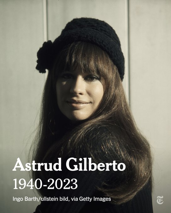 Astrud Gilberto is wearing a black hat with a flower, and has long brown hair with bangs. She is looking forward at the camera and smiling. The text reads, "Astrud Gilberto. 1940 to 2023." Photo by Ingo Barth/ullstein bild, via Getty Images.