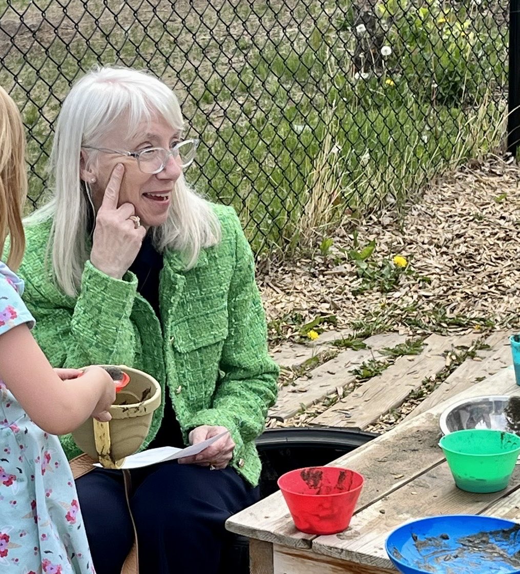 Dr. Beverlie Dietze visits and plays at a YMCA outdoor hub in Edmonton- children invite her to order soup!