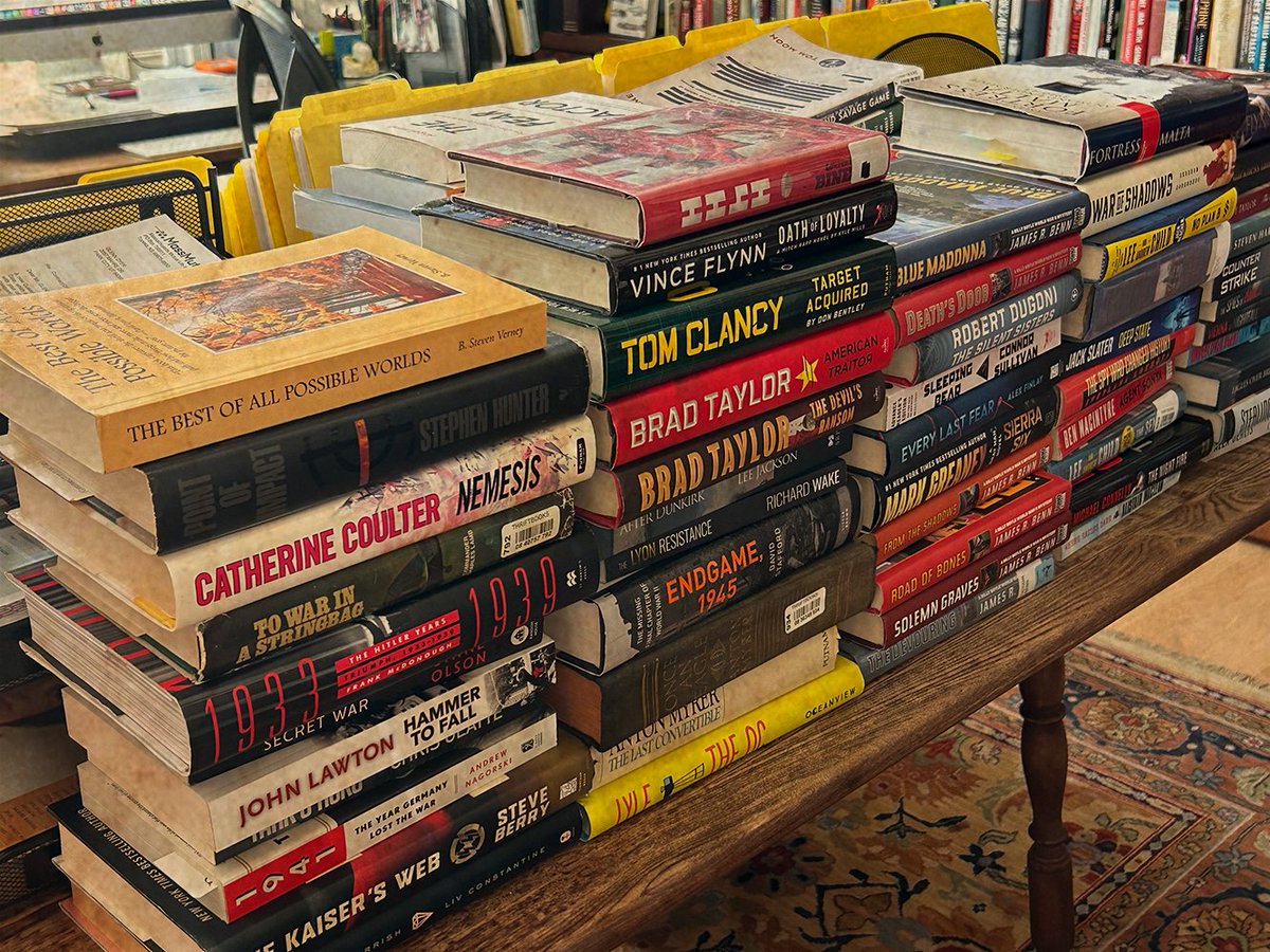 This is a picture of my “To Be Read” shelf. Good God, it’s really a table! Behind the stacked books is a row of more books!  Let me know what you've got queued up! #AmReading #ToBeRead #Fiction #NonFiction #ConorThornSeries #Books buff.ly/3BVAft3