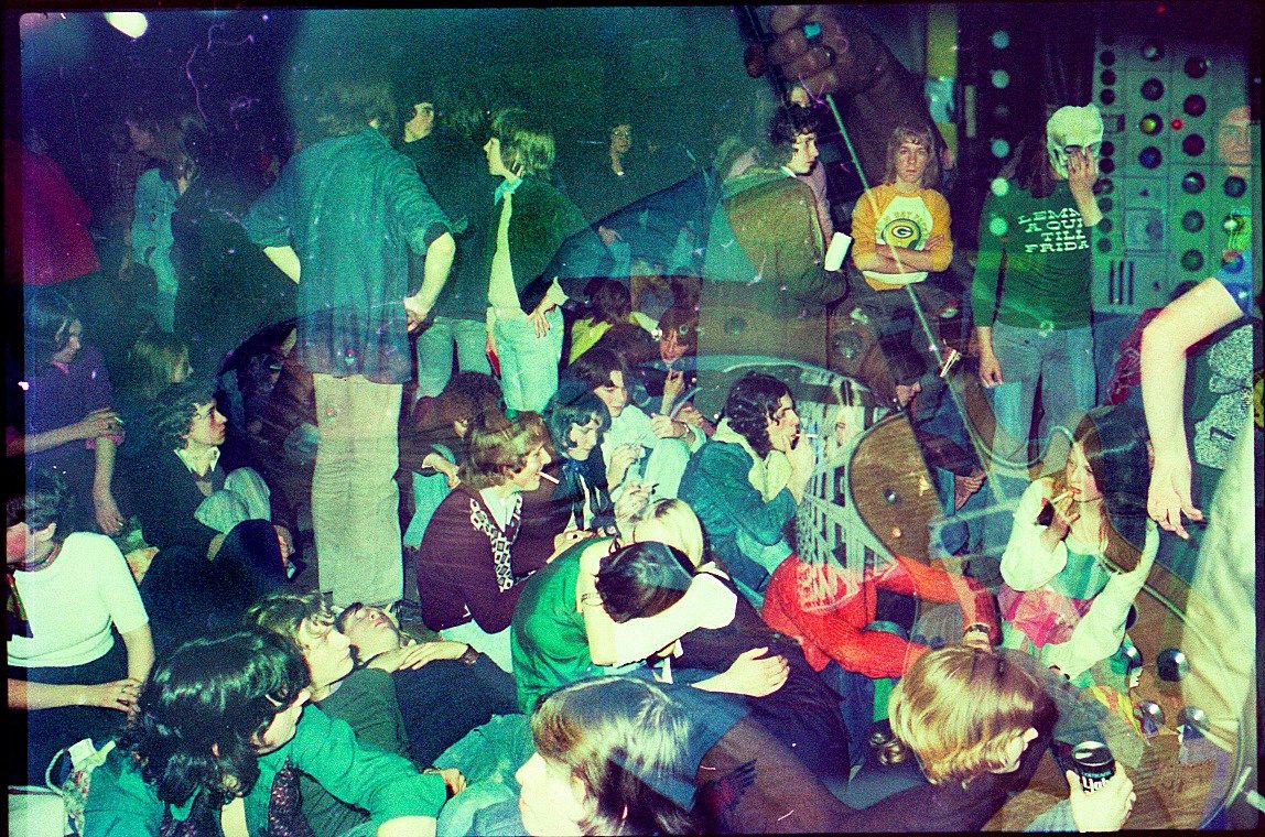 This is one of my favourite Hawkwind images, taken at Bracknell Sports Centre, 25 Jan 1975. It's a double exposure of the crowd over Dave Brock onstage. Look how YOUNG everybody is! And note the mask wearer with the 'Lemmy A Quid Till Friday' t-shirt (pic by Vin Miles) 1/2