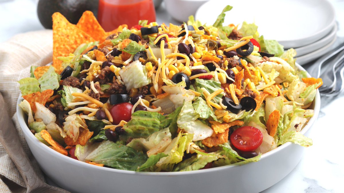 Easy and delicious Dorito Taco Salad made with ground beef with taco seasoning, black beans, fiesta corn, nacho cheese Doritos chips and more- a great summertime salad! Get the #recipe here: tinyurl.com/bddk6zxs #recipes #tacosalad #doritotacosalad #salad #HipMamasPlace