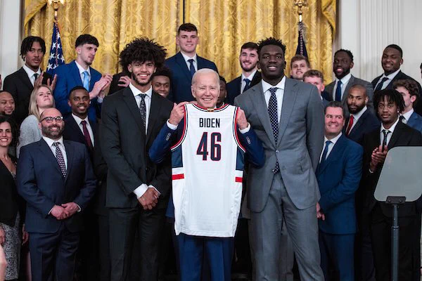 UConn MBB team presenting President Biden with a custom jersey