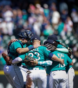 The Mariners infield dances with their arms around each other after the win.