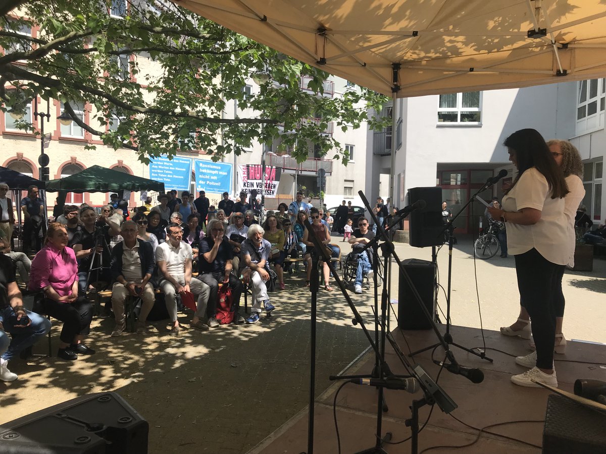 Menschen sind um eine Bühne auf dem Hülya Platz in Ffm versammelt.