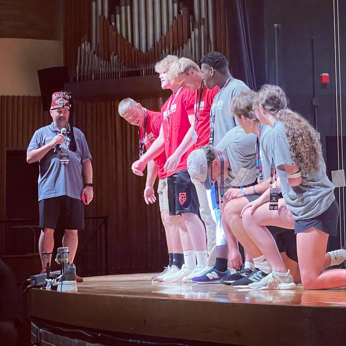 Players learn about Shriners Children’s with the one hand shoe tying challenge with Poppy. #BeyondTheField #MoreThanAGame #NSB65