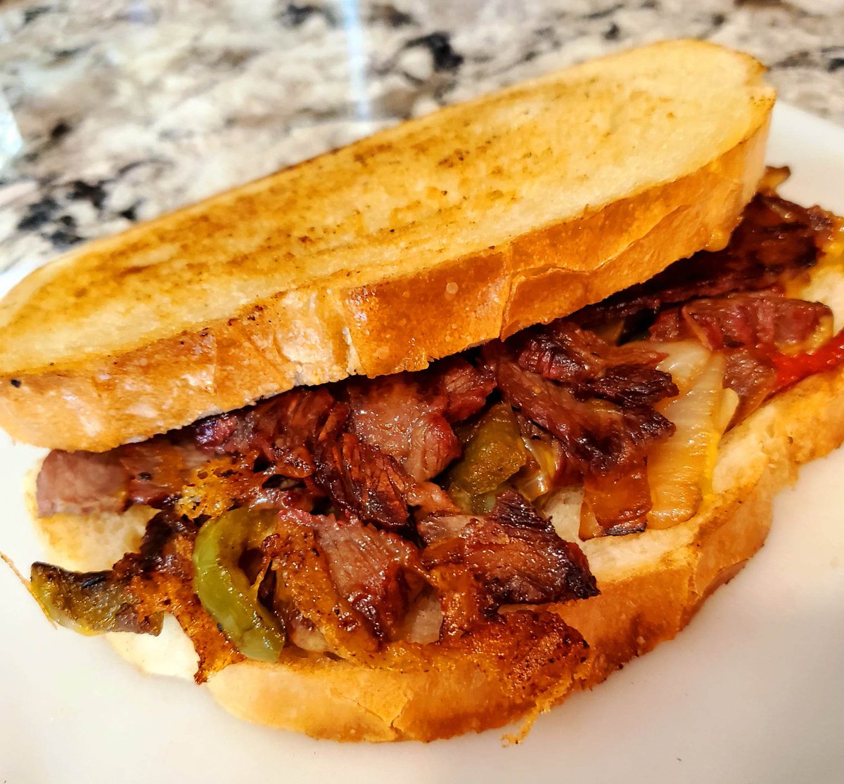 Steak and cheddar w/ balsamic glazed peppers and onions and a home made garlic aioli courtesy of the neighbor's chickens.  Toasted up on the Blackstone on sourdough bread.