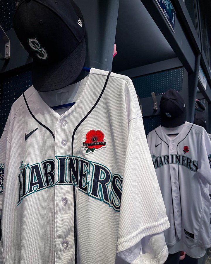 The Mariners home white jersey hangs in the clubhouse, with a patch of a red poppy that reads “Lest We Forget”