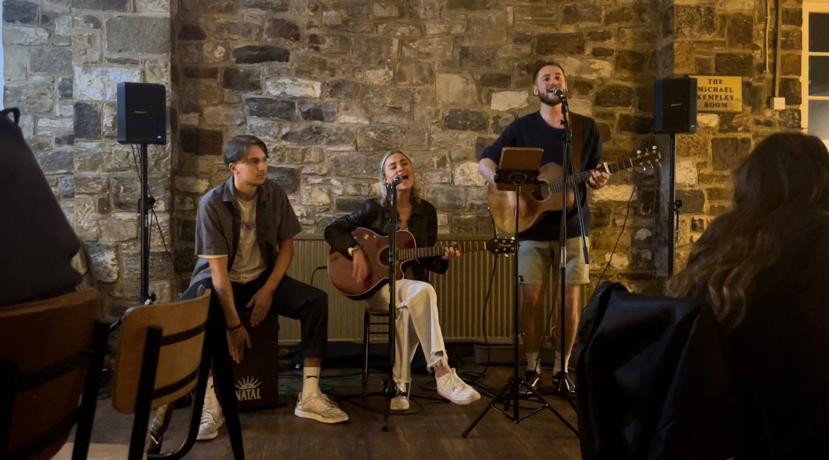 2 years ago today me, <a href="/JDev_Smith/">Joe Deverell-Smith</a> and <a href="/lydiaturnbull4/">lydia turnbull</a> had our first ever gig as ‘Sinistrum’. If you said before uni that me, a rock drummer, would be playing cajon in a folk/acoustic trio, I would’ve laughed…But I’ve never been happier on stage than I have been with these two ☺️