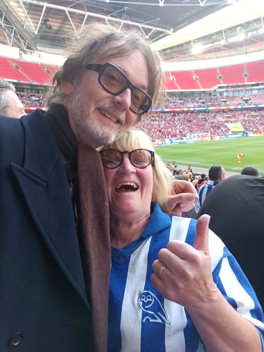 ClaireKingswood's tweet image. Yesterday was just incredible and to top it off Sheffield's finest Jarvis Cocker was sat in front of us. Mi mother had to get a photo with him. See you back in Sheffield in July for a boogie you absolute legend! #swfc 🔵⚪️🦉