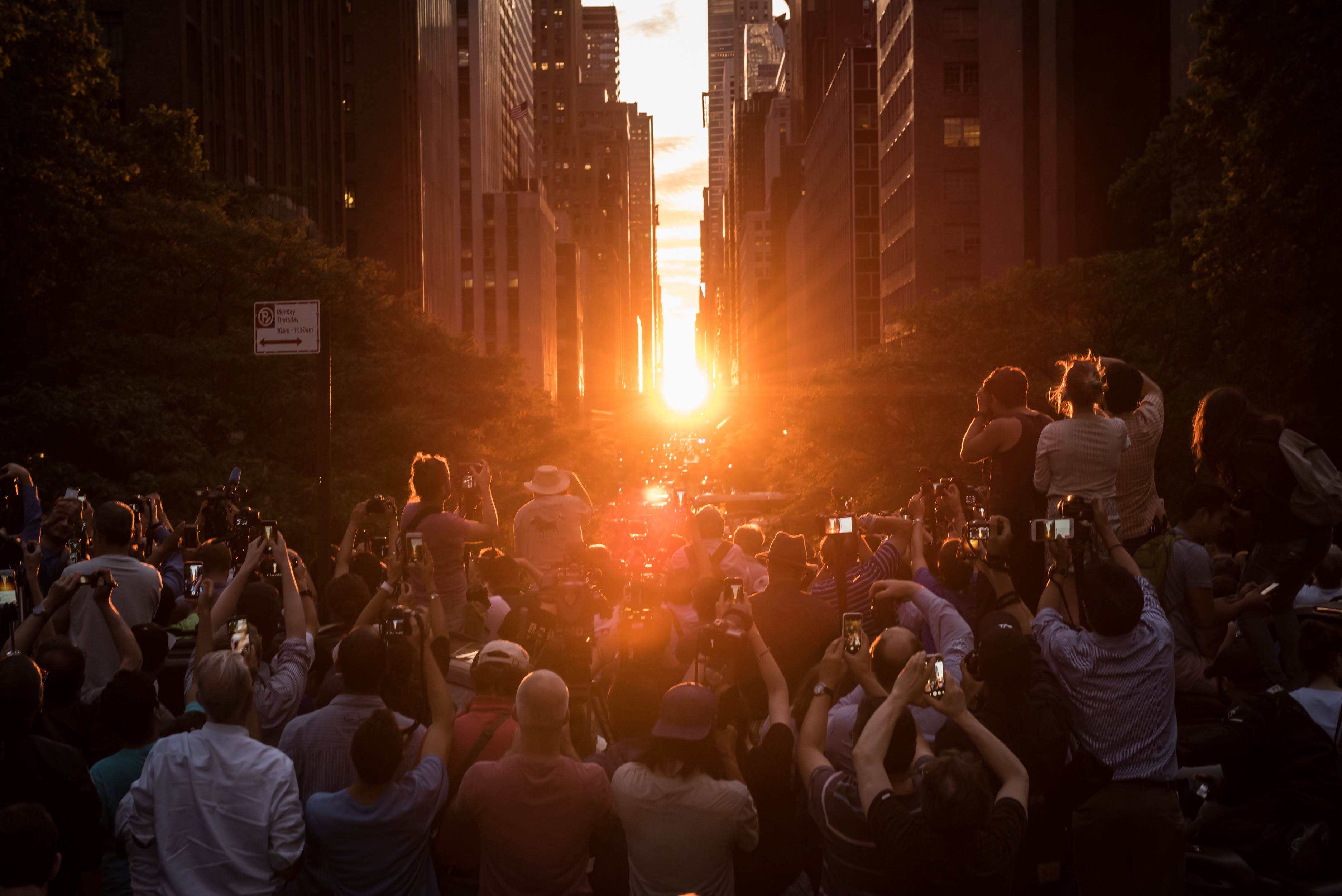 A group of people taking photos of the sunset. 