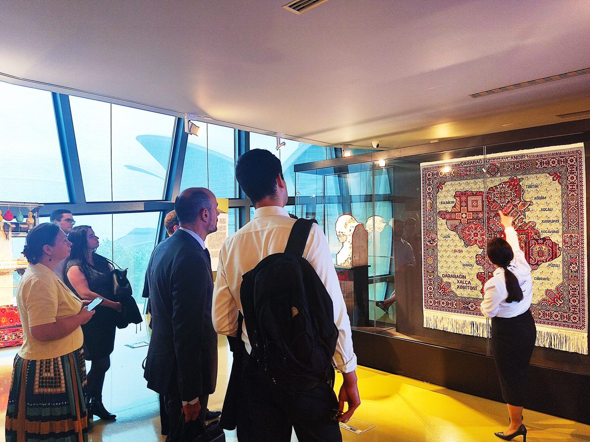 AZMissionEU's tweet photo. #COEST Delegates' guided tour in #Baku today began with a heartfelt visit to Martyr's Alley, honoring 🇦🇿 's fallen heroes, proceeded to the rich artistic tradition at the Carpet Museum, and concluded in beautiful historical Old City. A day embodying the spirit of Azerbaijan. #MaidenTower 
#OldCityBaku