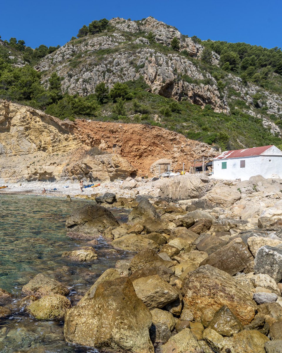 costablancaorg's tweet image. Uno de nuestros tesoros más especiales, la Cala del Llebeig en #Benitatxell 🩵🏝️

Aún conserva antiguas casitas de pescadores. 🏠🐟

Dos rutas senderistas te llevan a ella; la de los Acantilados desde Cala Moraig y la del Barranco de la Viuda.

Si la visitas, cuídala #CostaBlanca