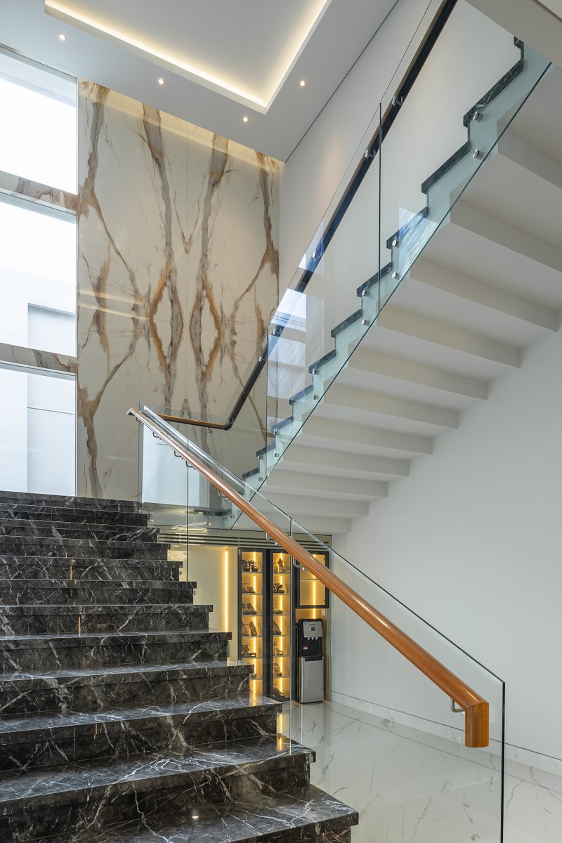 ConArchStudio's tweet photo. The stairs leading to the 2nd floor of this house are U-shaped with a void in the middle of the stair area, the stair floors use marble material and the stair railing materials use glass with wooden handrailing and this staircase has a view to the swimming pool https://t.co/lcn6zwvHYR