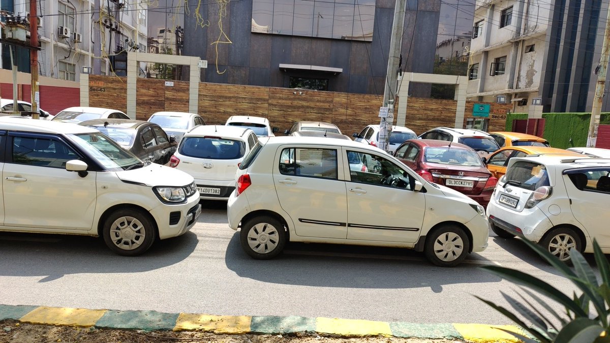 ashish_gzb's tweet photo. @noidatraffic @noidapolice is this allowed? Half of the road is captured by parking vehicles. Is not this the duty of building to provide parking? https://t.co/6xmN22u5W9