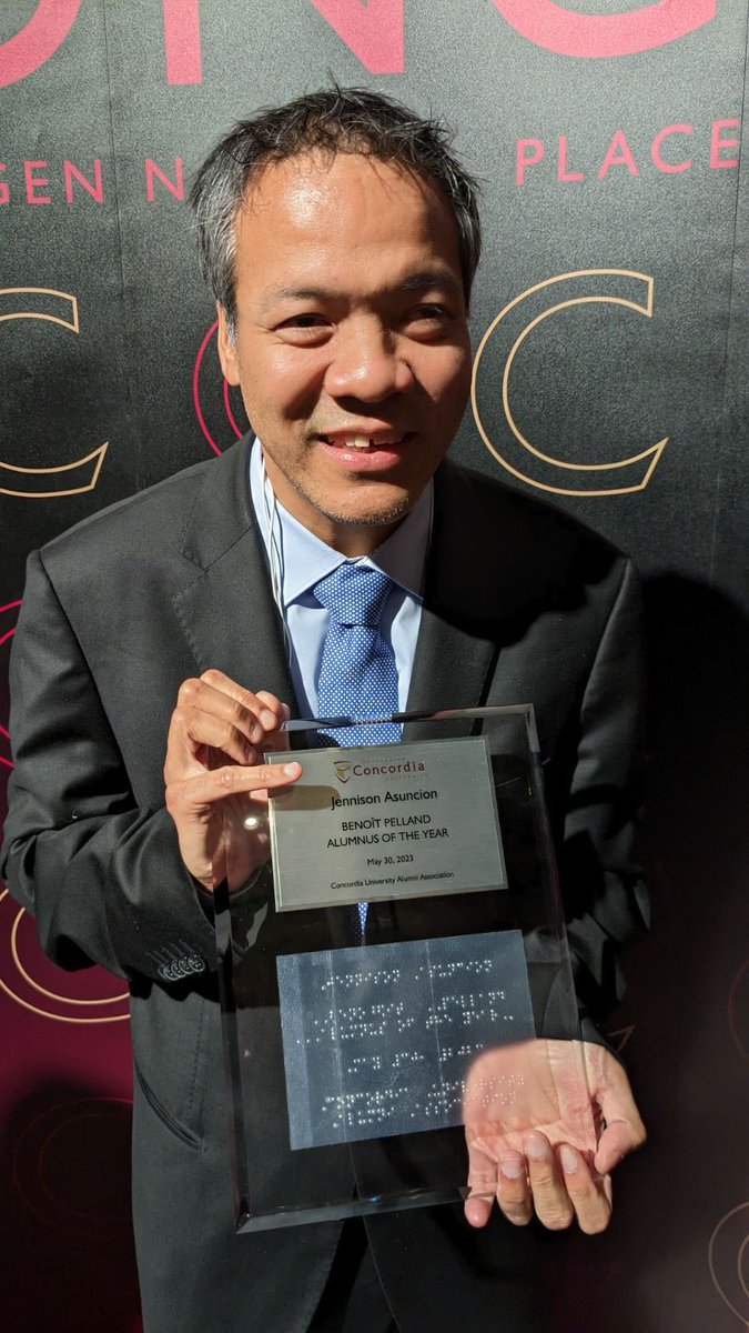 Jennison's tweet photo. Was great to be briefly back in Montreal being recognized by ⁦@ConcordiaAlumni⁩ ALT text “Me, suited up, holding my Benoît Pelland Alumnus of the Year plaque from my alma mater.” ⁦@Concordia⁩ https://t.co/7eV1SxbxrC