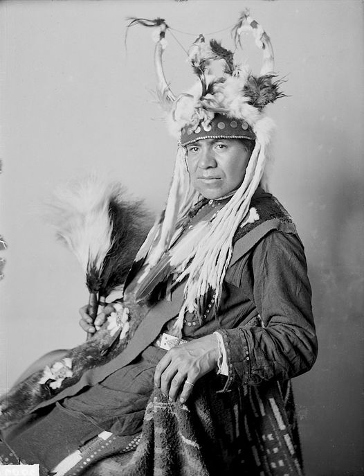 Indigenoususa's tweet photo. William Charlie, Umatilla Interpreter, in Native Dress with Headdress and Ornaments and Holding Two Fans - https://t.co/tpRjKjvwBO