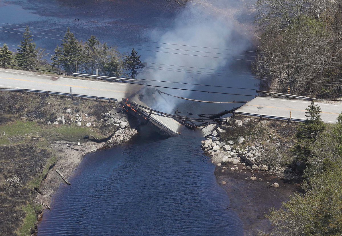 NateTWN's tweet photo. The collapsed bridge between Clyde River and Port Clyde smoulders 

Courtesy: Communications Nova Scotia #nsfires https://t.co/zA3Yc8cgXU