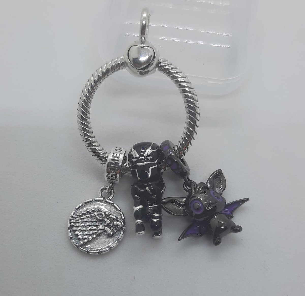 Colgante con charm de #JuegoDeTronos #CasaStark charm de #BlackPanther y un pequeño Belcebú.