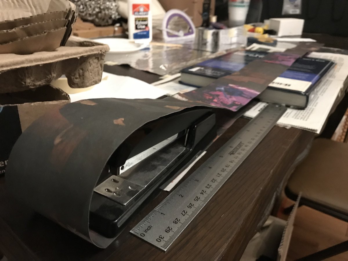 Puptrait's tweet image. Attempting a new ruff collar technique.

Started with a patchwork of @baltbeat clippings and glued them into a single 6' long strip. Now we dry.

Tomorrow is the tricky bit. Need to make 72x identical folds and stitch it together like this prototype - all while watching a toddler