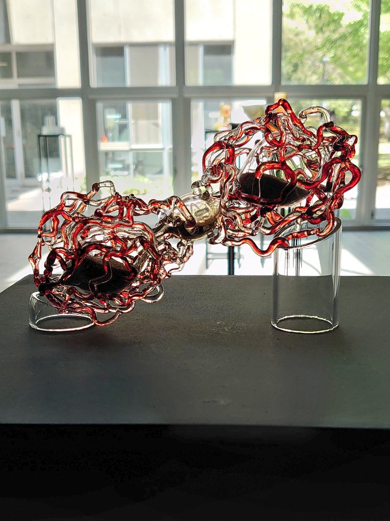 #工芸学科　#自由制作　#バーナーワーク
「廻脈（かいみゃく）」
砂も、血液も、
生も、死も、
廻り廻って還っていく。

　中心の球を心臓、両端の器を身体に、流れる砂を血液に見立てました。
　砂を循環する砂時計と血液を廻らせる心臓。流れ落ちるのは命の刻限か。あるいは...