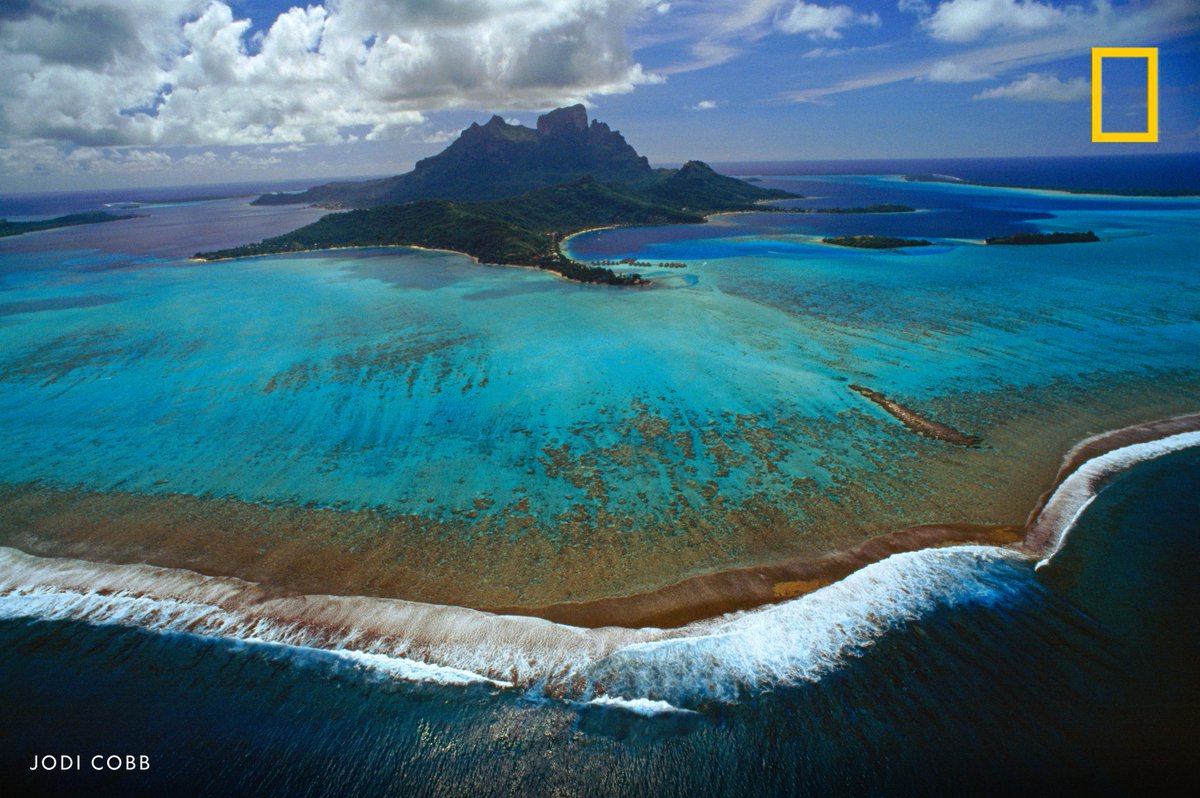 Elevated view of surf breaking on the coral reef that rings Bora-Bora in French Polynesia.