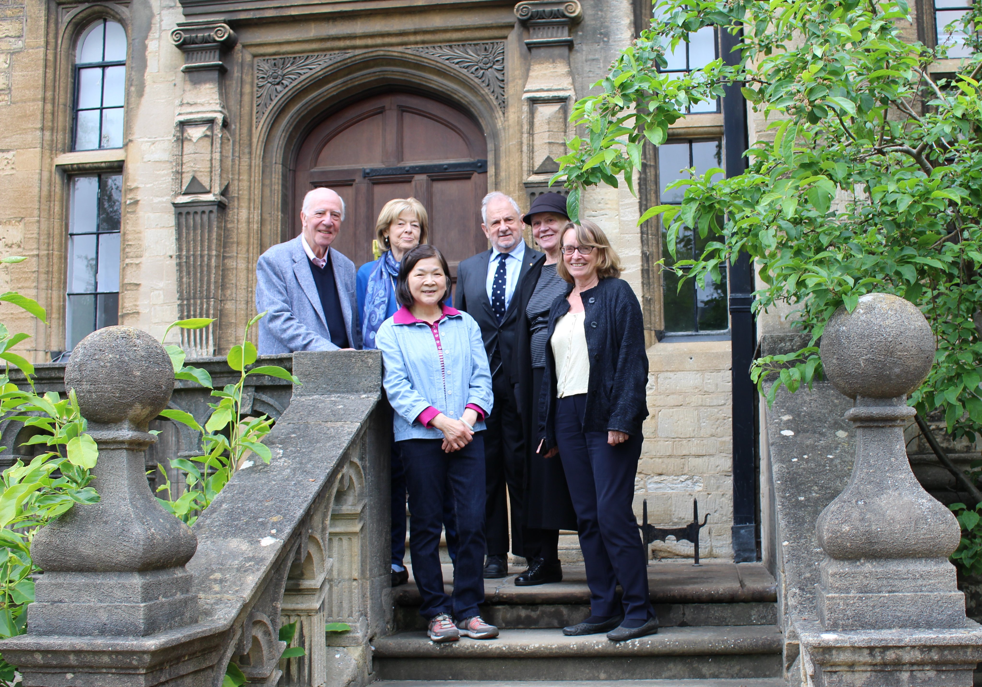 Lana Ip stands on the steps of the Trinity President's Lodgings with president Hilary Boulding and former presidents Ivor Roberts and Michael Beloff and their wives.