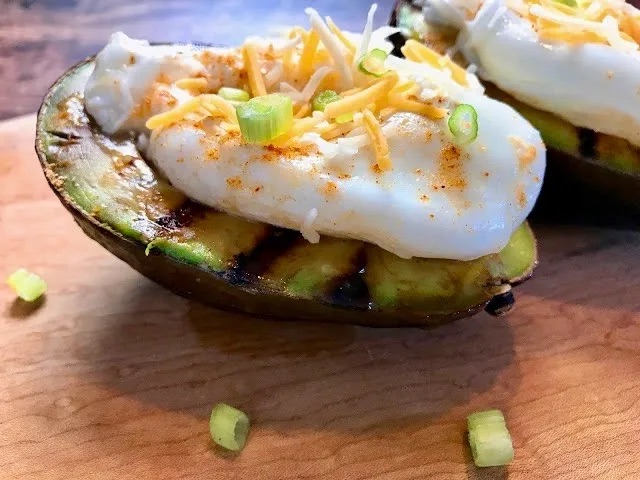 Grilled Avocados with Poached Eggs. Creamy avocado halves, quickly charred on a hot grill pan, dusted with taco seasoning and topped with a perfectly poached egg and shredded Mexican cheese. Total perfection! #nationaleggday robinmillercooks.com/f/grilled-avoc…
