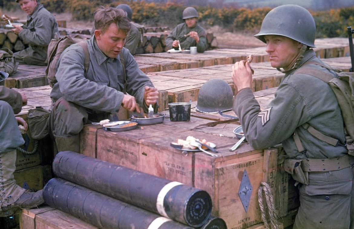American combat engineers eat a meal atop boxes of supplies being stockpiled for the impending D-Day invasion of France in Stratford-on-Avon, England  in 1944. 🪖