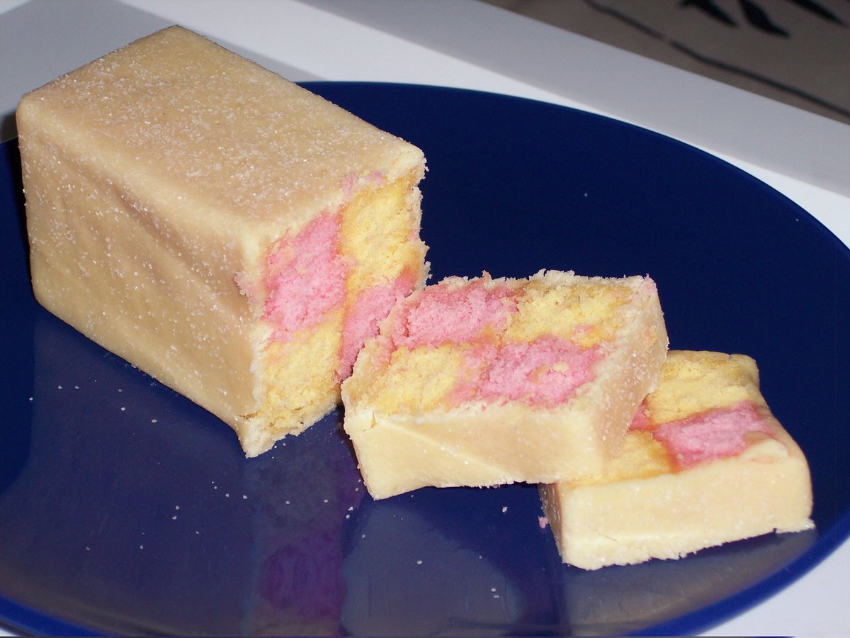 Battenberg cake (or Church Window Cake) is pretty as it is tasty. Four alternating blocks of sponge are glued together with apricot jam and sealed in marzipan.

Though its named after a town in Germany, this cake is distinctly British 🇬🇧

#foodhistory #baking #cake #british