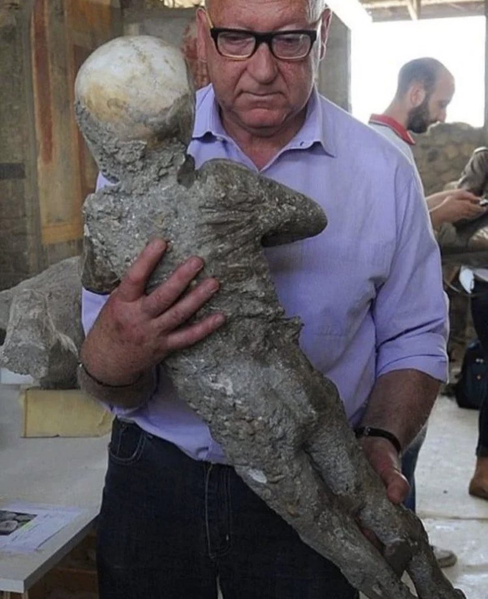 An archeologist carefully cradles a plaster cast of a child lost during Pompeii in his hands, feeling the weight of history and tragedy within it. The cast is a sad representation of the horrifying event that unfolded nearly two millennia ago in the ancient Roman town of Pompeii.