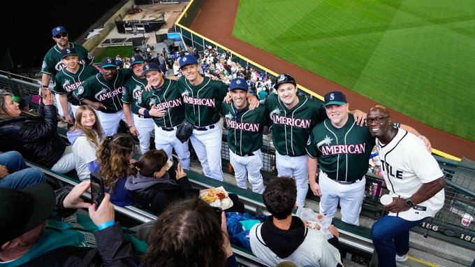 A group of fans dressed as each of the 2001 Mariners pose for a photo in the left field bleachers with the real Mike Cameron.