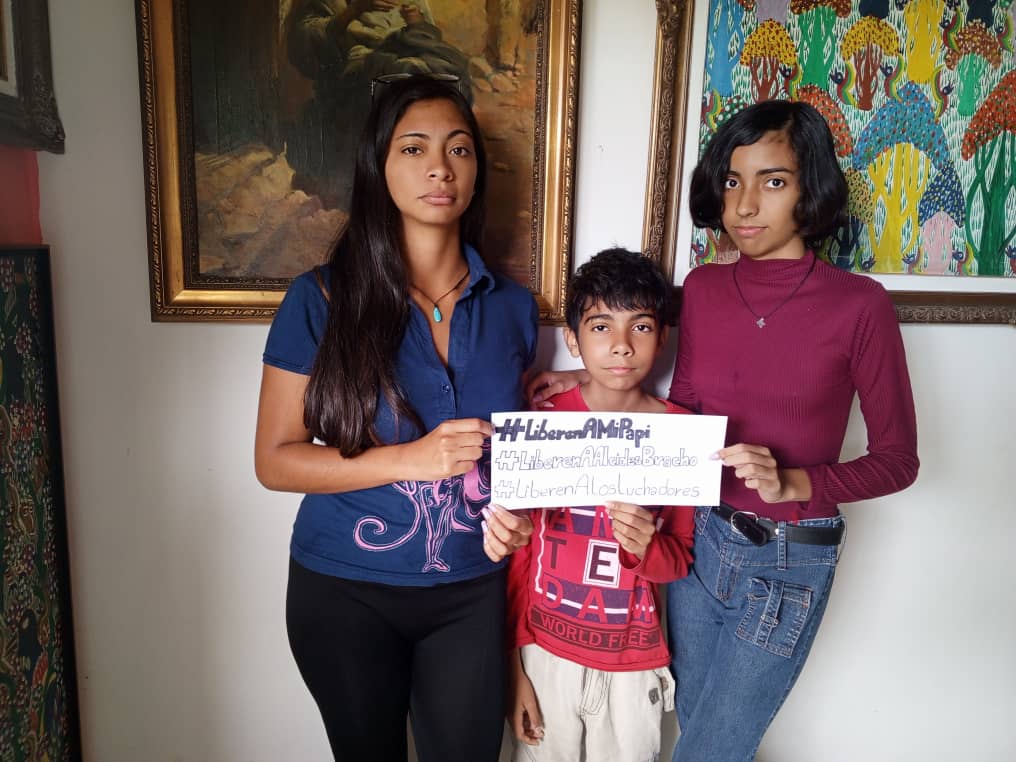 Bandera_Roja's tweet photo. ES INOCENTE | El compañero Alcides Bracho, @aljobrav, revolucionario, docente y artista plástico, tiene casi un año preso por órdenes de un juez corrupto y por un juicio amañado. Sus hijos exigen hoy, #DiaDelPadre, su libertad.

#LibertadParaAlcides 

#LiberenAlosLuchadores https://t.co/rihBEDdiXW