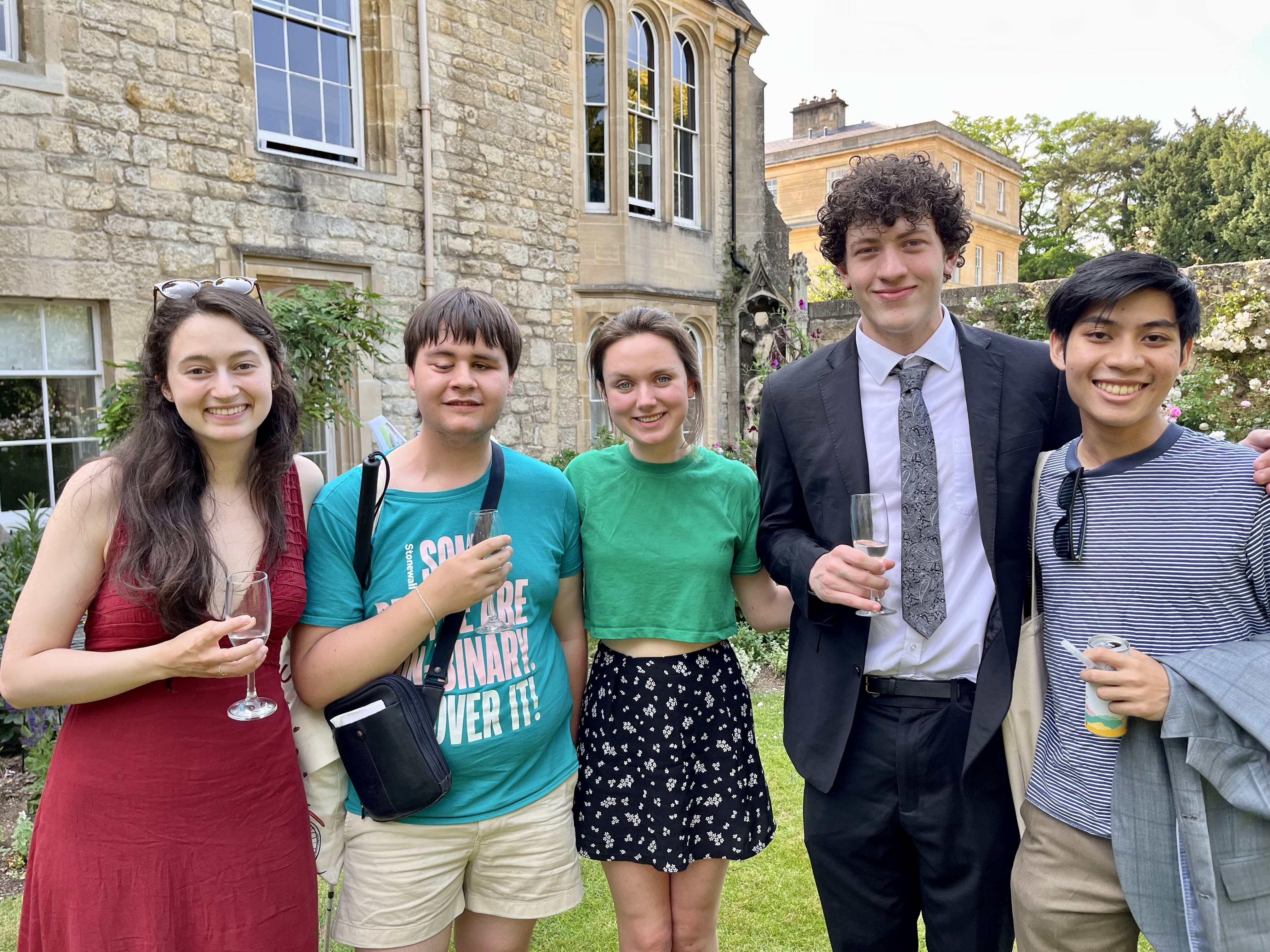 A group of three boys and two girls stands at Trinity leavers drinks.