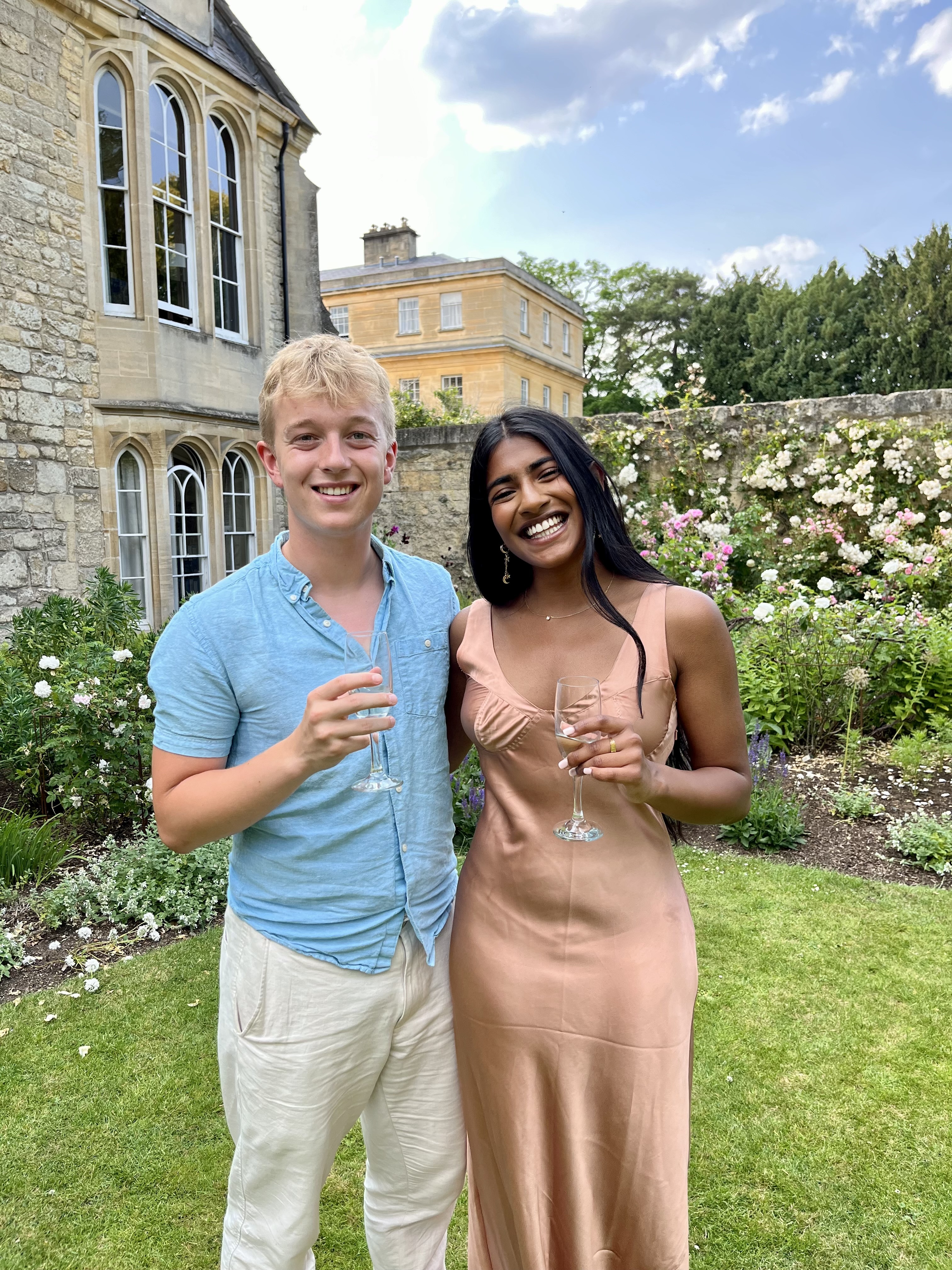 Two students - male and female - holding drinks at Trinity leavers drinks.