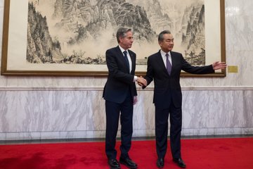 Secretary Blinken shakes hands and poses for a picture with Central Foreign Affairs Office Director Wang Yi.