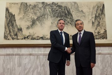 Secretary Blinken shakes hands and poses for a picture with Central Foreign Affairs Office Director Wang Yi.