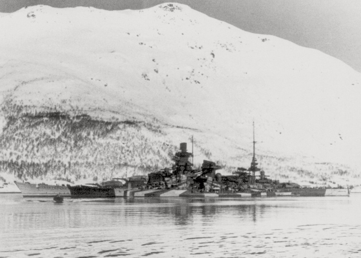 Date: October 1943. Location: 70°02'15'N, 22°19'41'E. Event: German battleship Scharnhorst is moored in the Langfjorden soon after the raid on the Island of Spitzbergen. Sitting along Scharnhorst's port side, destroyer Z 15 Erich Steinbrinck seems to be a part of her camouflage.