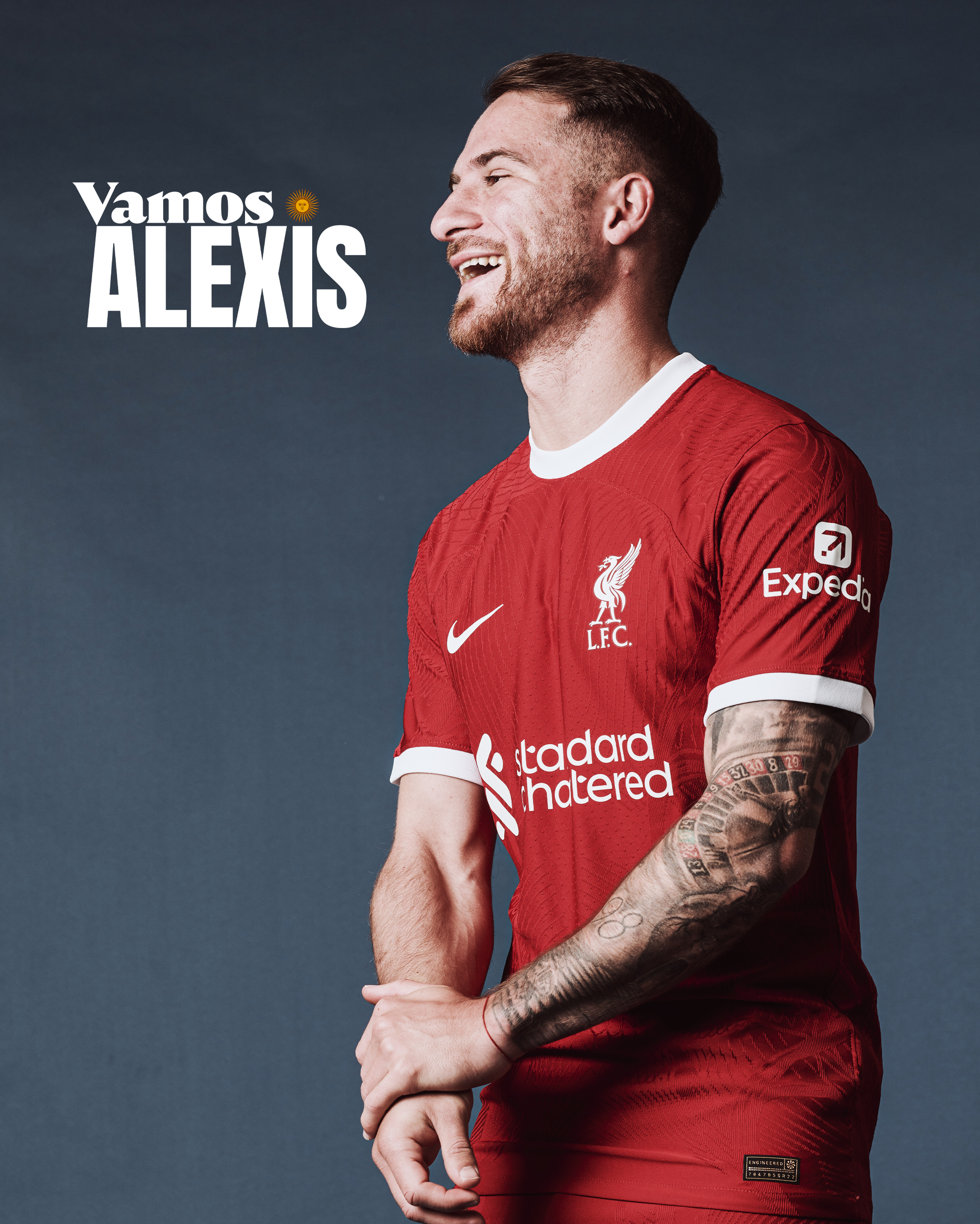 New signing Alexis Mac Allister smiling in the new Liverpool 23/24 Nike home kit during a photoshoot.