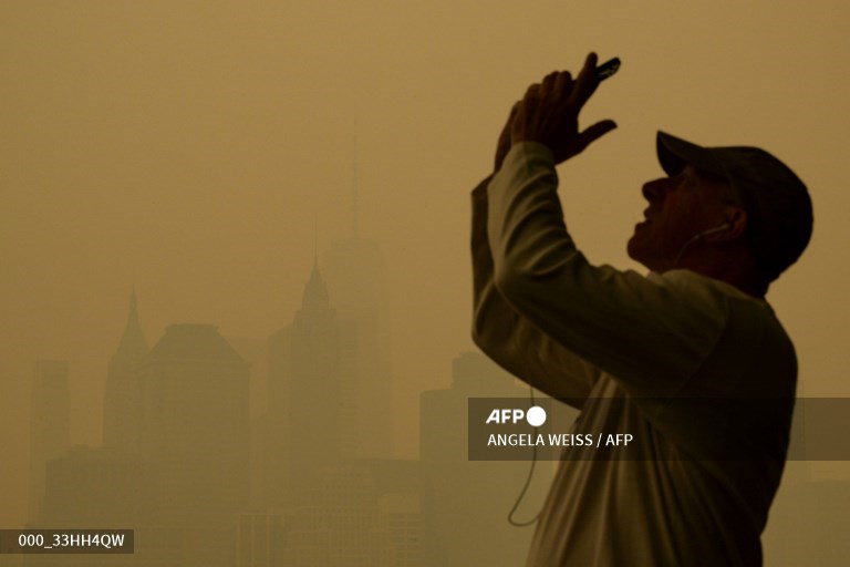 AFPphoto's tweet photo. Canada wildfires shroud New York in apocalyptic haze. #AFP 
📸 @timothyaclary 
📸 @angelaweissfoto https://t.co/dXoGB51aQw