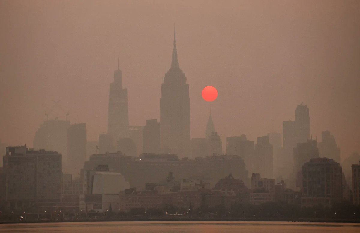 GaryHershorn's tweet photo. The smokey air seemed thicker to start the day on Thursday in New York City as the sun came up behind midtown Manhattan and the Empire State Building #newyork #newyorkcity #nyc @EmpireStateBldg @agreatbigcity #sunrise #smoke https://t.co/d8YOQOTHae