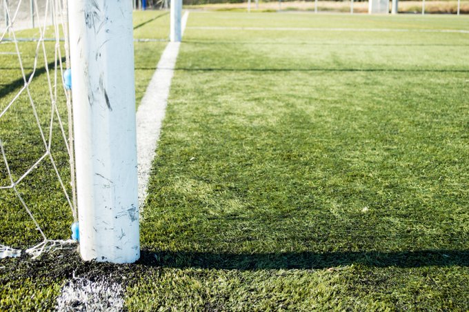 A soccer goal is shown from an angle at the sidelines. 