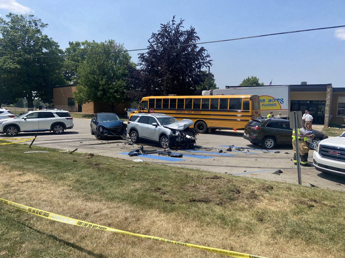 joelafurgey's tweet photo. One minor injury to a parent was reported after a truck hits 3 vehicles in a Hudsonville elementary school parking lot, landing between a bus and the building just minutes before students were suppose to walk out the door for the school year. https://t.co/Qpwu9tLpO1