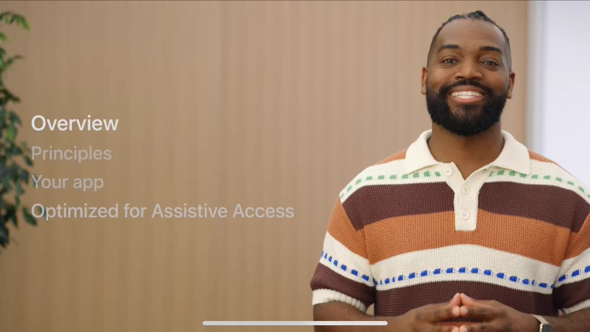 Screenshot from my WWDC session “Meet Assistive Access”. I’m smiling and wearing a horizontal striped shirt with cream, dark and light brown stripes. Also in view shown is an outline of the presentation as with the sections: Overview, Principles, Your App, & Optimized for Assistive Access.