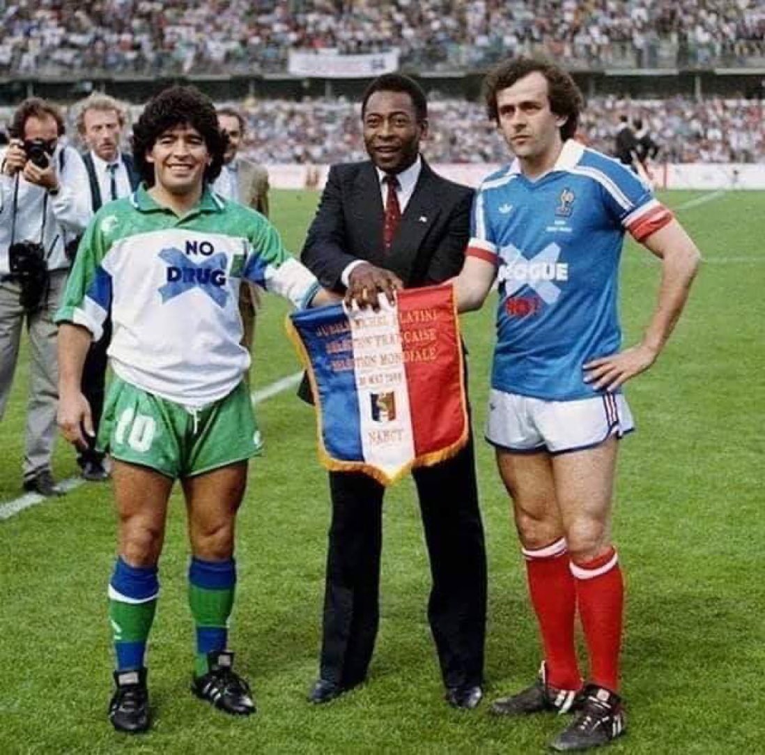 The year is 1986 or 1987. 

Diego Maradona's shirt says 'No drugs' and on Michel Platini's shirt it says 'No to corruption'.
Diego Maradona was addicted to drugs , 
And Platini, urge to make extra cash, ruined his reputation for ever.