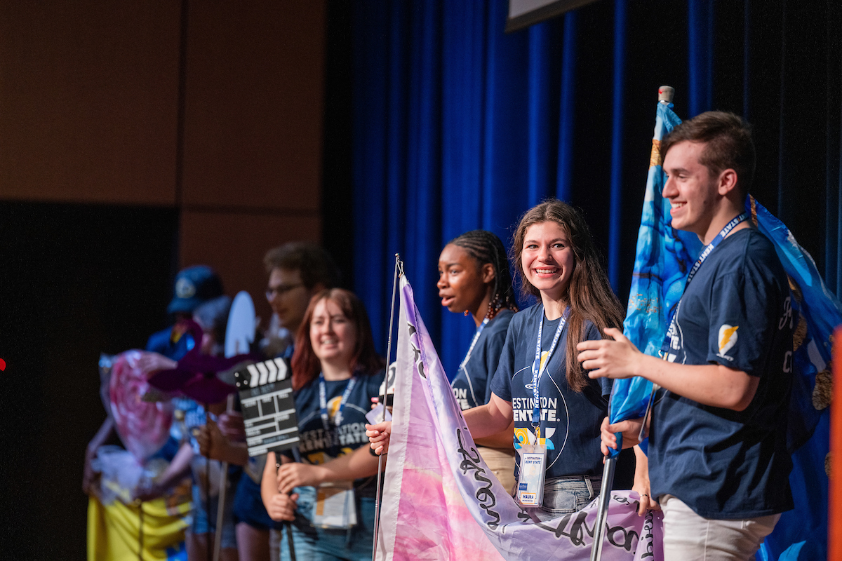 Destination Kent State Flashguides take the stage in the Student Center Ballroom with flags and other props to welcome incoming students and their families. 