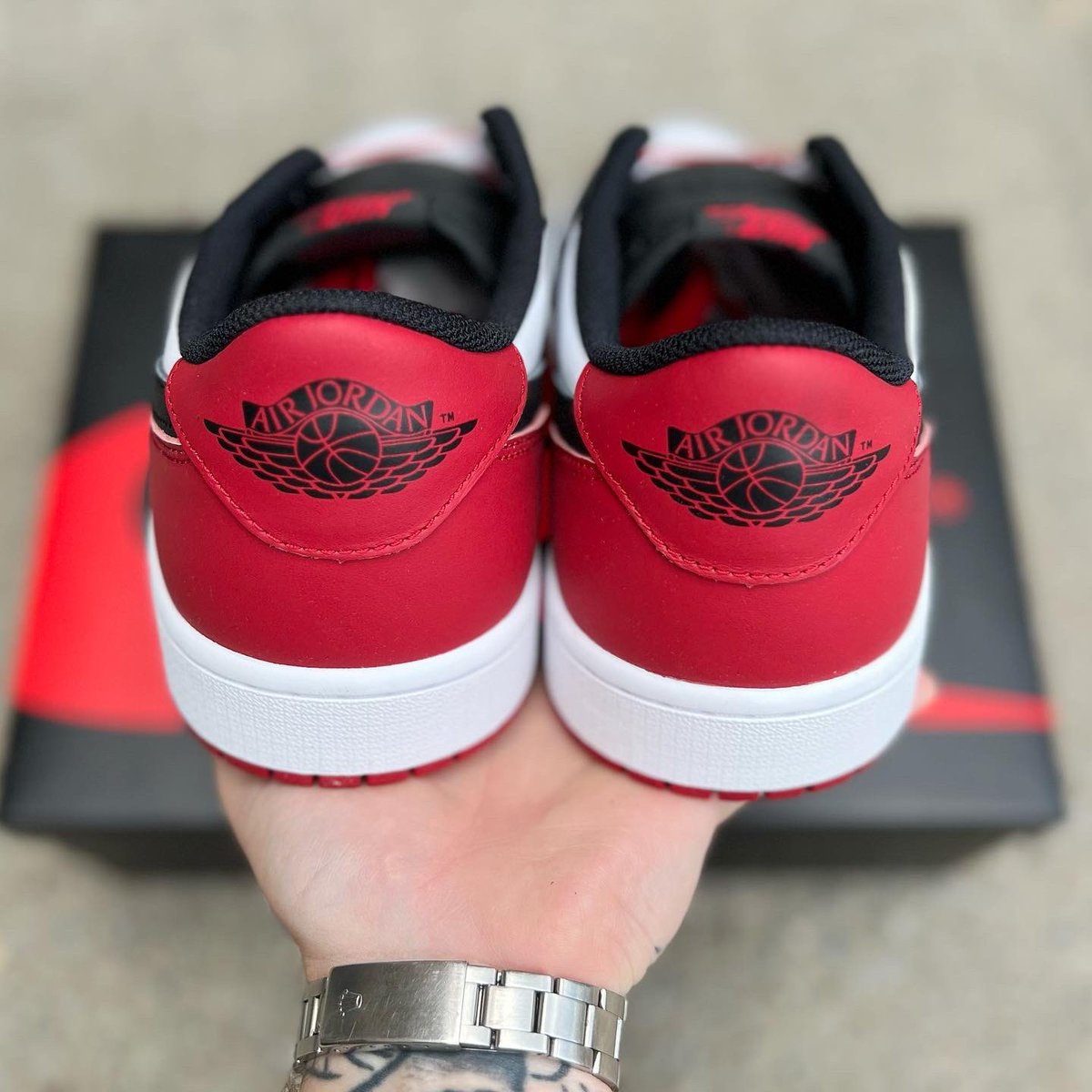 Black Toe Lows in hand photo with full retail packaging.